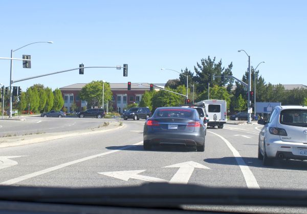 写真2　本社（Menlo Park キャンパス）入り口前。右手に良いねサインのタイトルが見える。偶然かあたりまえか、目の前はTesla S。ガレージには電気自動車がいっぱい。