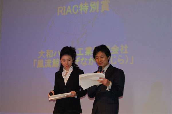 授賞式の司会を務めた花王（株）本間充氏（左）と日本IBM（株）樋渡友子氏（右）。投票後の結果をその場で集計中。