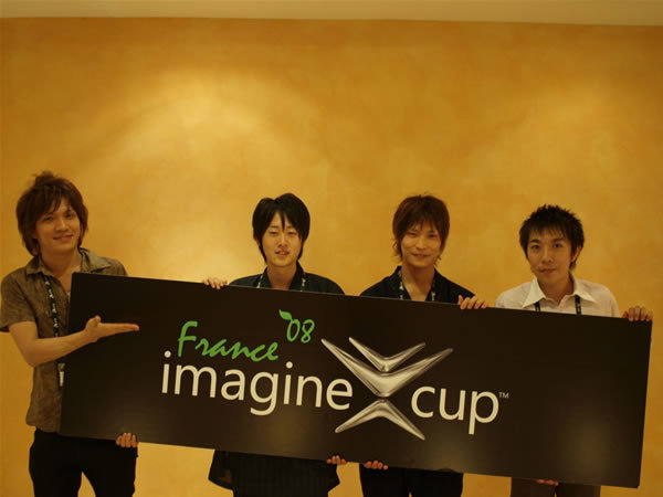 写真6：ホテルに置いてあったImagine Cupのパネルと一緒に記念撮影